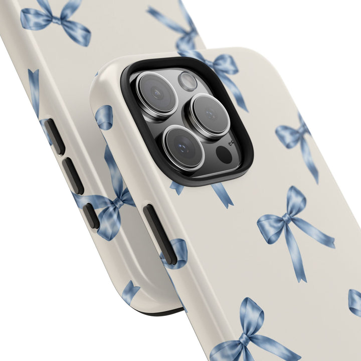 Sunday Theory protective phone case with a cream background and watercolor blue bow pattern, glossy finish.