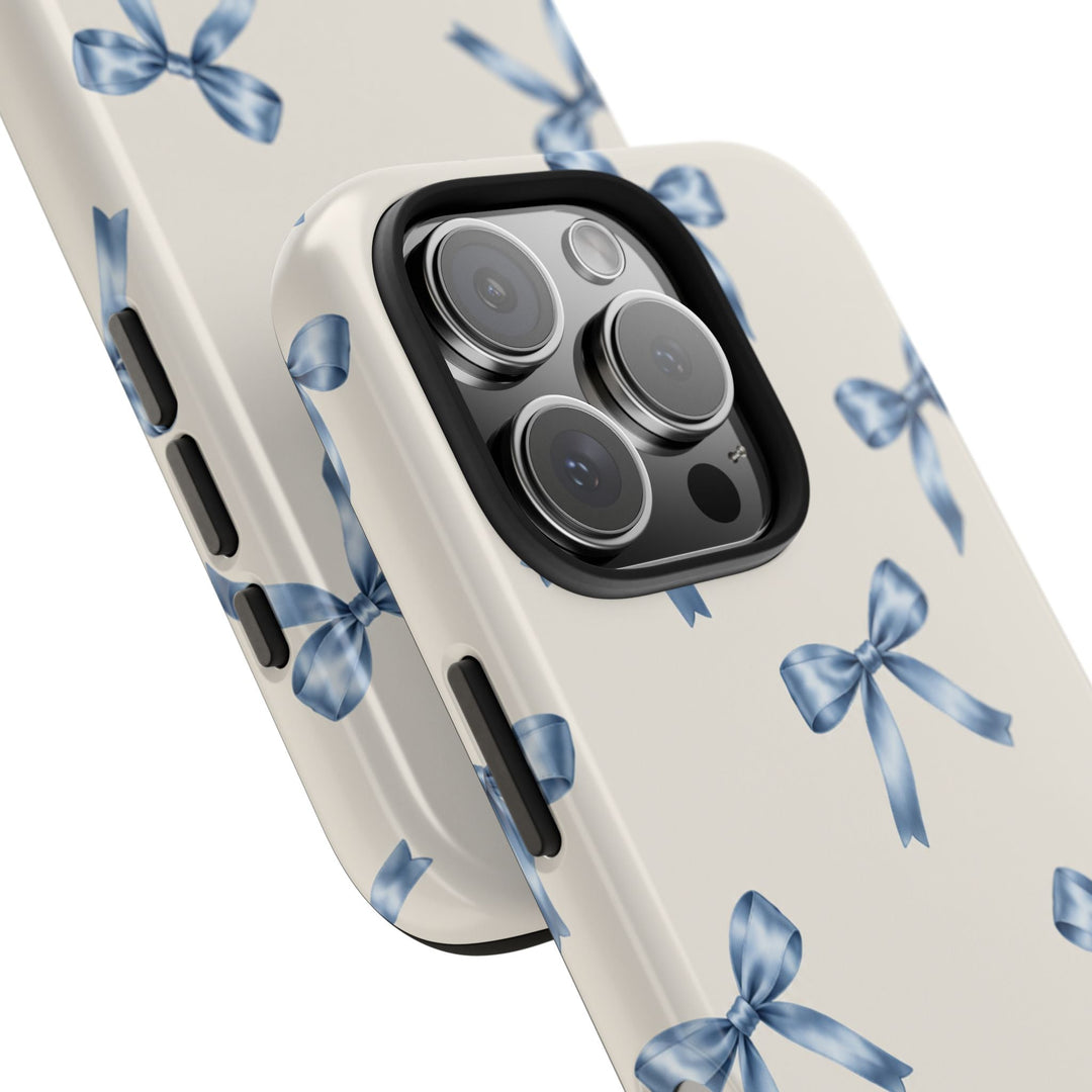 Sunday Theory protective phone case with a cream background and watercolor blue bow pattern, featuring a glossy finish.