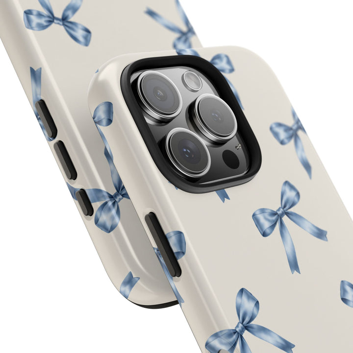Sunday Theory protective phone case with a cream background and watercolor blue bow pattern, featuring a glossy finish.