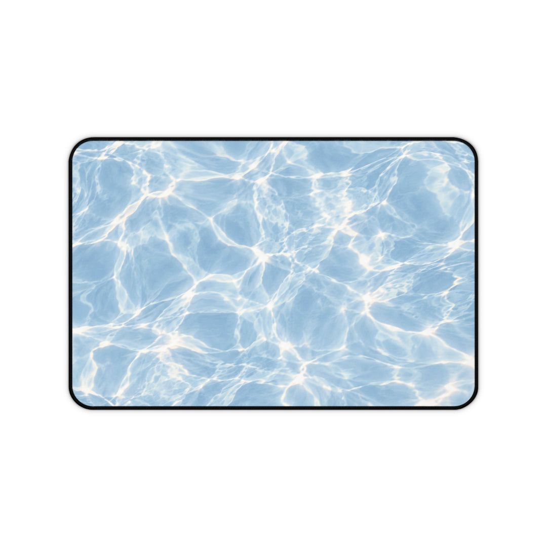 Sunday Theory Blue Hour desk mat with a shimmering blue pool water print, neoprene surface, and black hemmed edges.