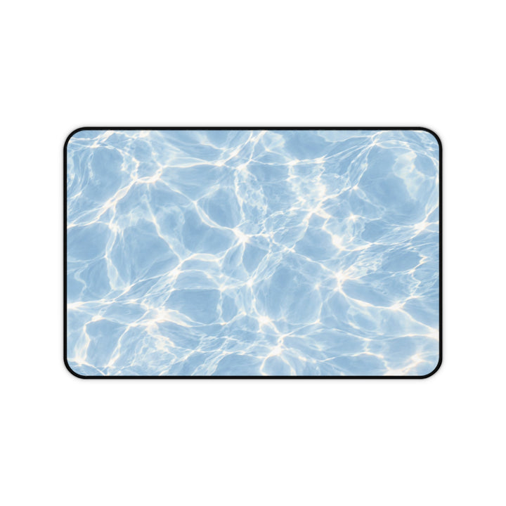 Sunday Theory Blue Hour desk mat with a shimmering blue pool water print, neoprene surface, and black hemmed edges.