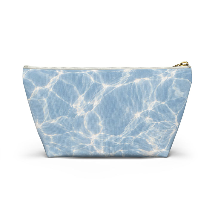Sunday Theory blue T-bottom accessory pouch featuring a rippling pool water print and a gold-colored zipper.