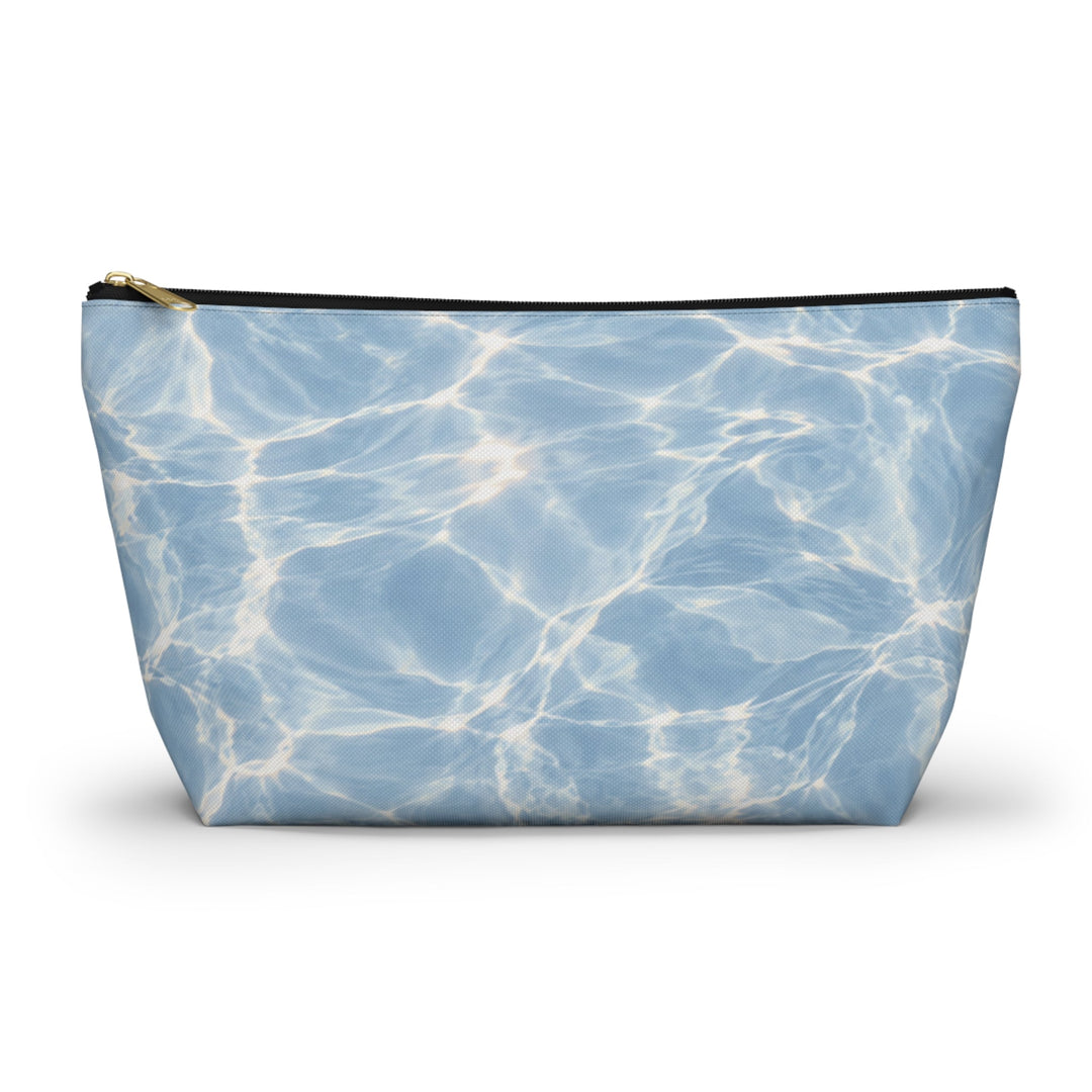 Sunday Theory blue T-bottom accessory pouch with a rippling water print and gold zipper, made of durable polyester.