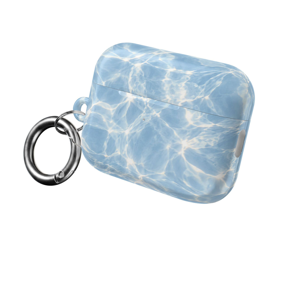 Sunday Theory glossy blue water ripple pattern polycarbonate AirPod case with a silver carabiner clip.