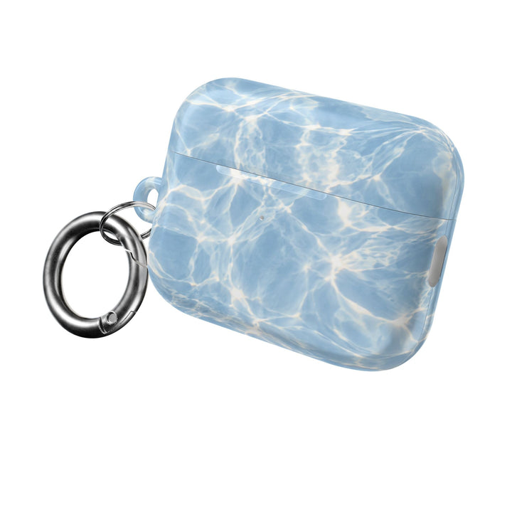 Sunday Theory glossy blue water ripple pattern polycarbonate AirPod case with a silver carabiner clip.