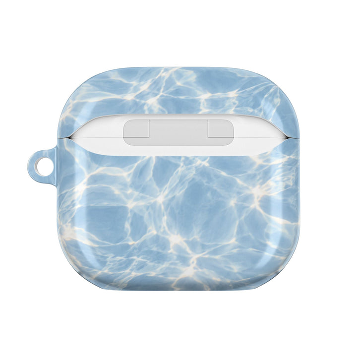 Sunday Theory glossy blue water ripple pattern polycarbonate protective case for AirPods with a side carabiner loop.