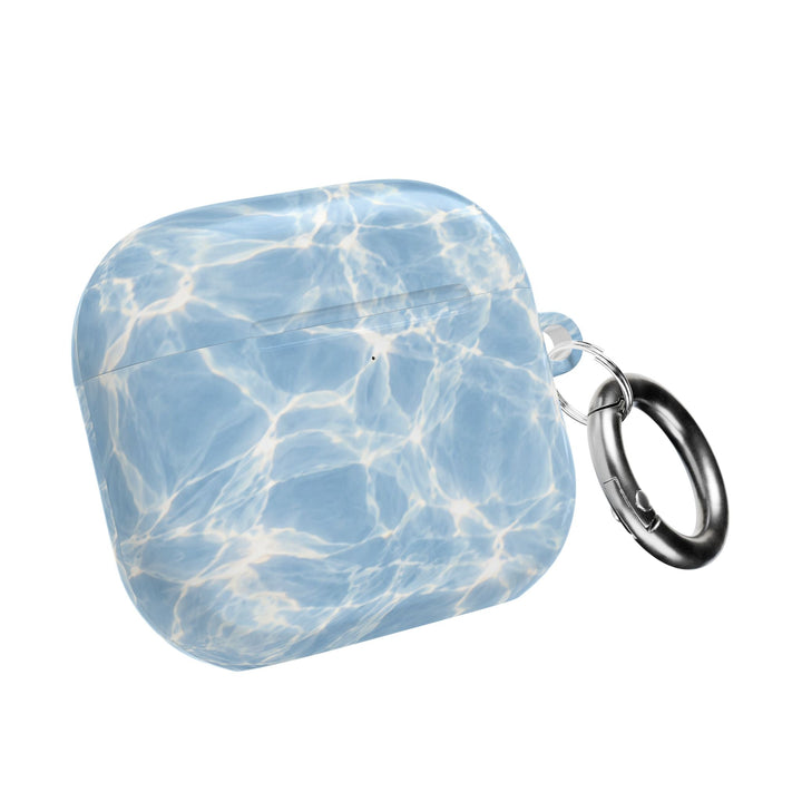 Sunday Theory glossy blue water ripple pattern AirPod case with a silver carabiner for easy attachment.