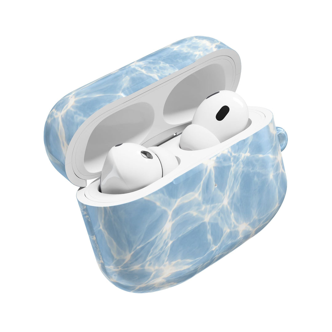 Sunday Theory glossy blue water ripple polycarbonate AirPod case with white earbuds inside on a white background