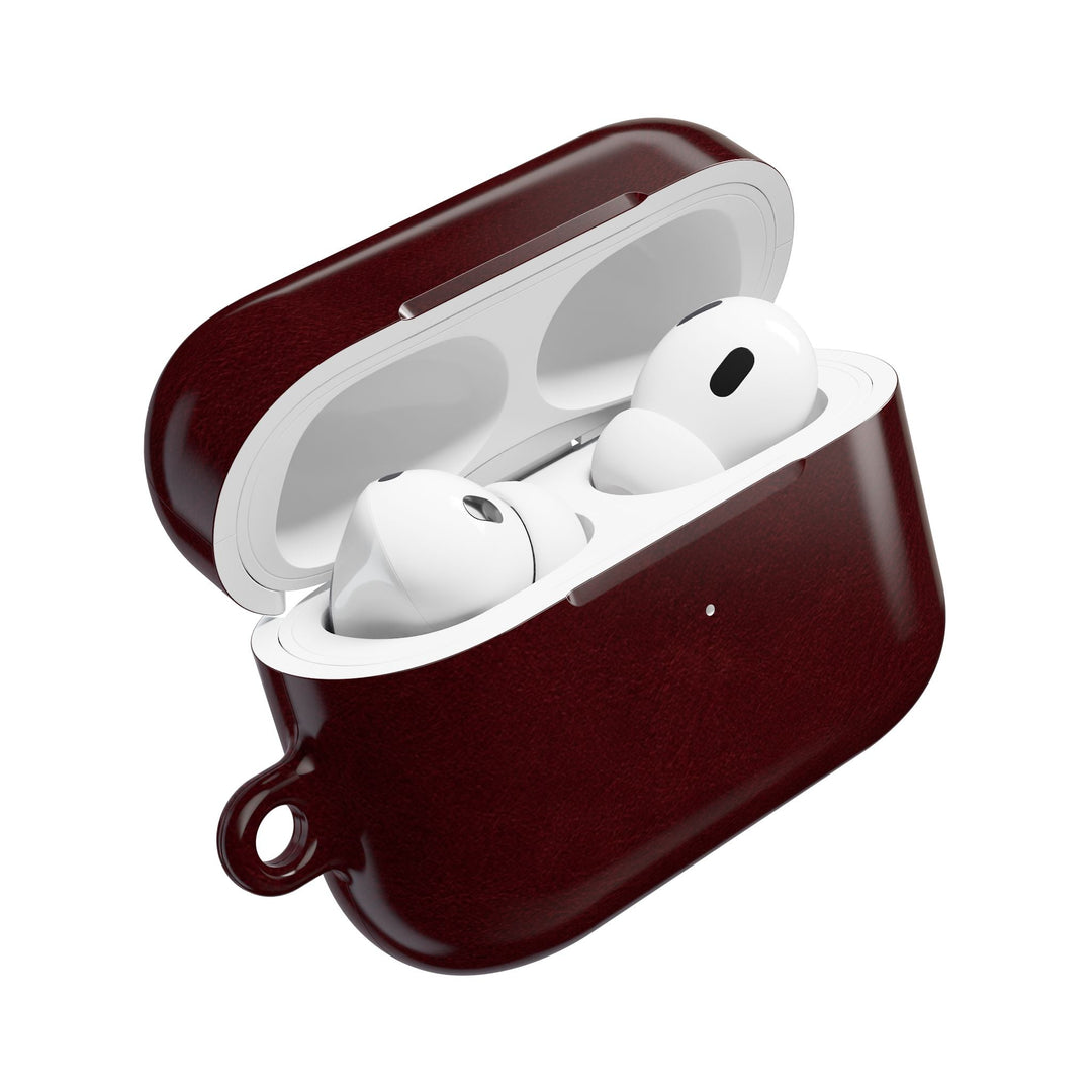 Sunday Theory burgundy glossy polycarbonate AirPod case with white wireless earbuds inside and a side keyring loop