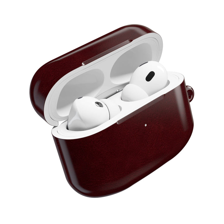 Sunday Theory burgundy polycarbonate AirPod case with white wireless earbuds inside, featuring a slim glossy finish.