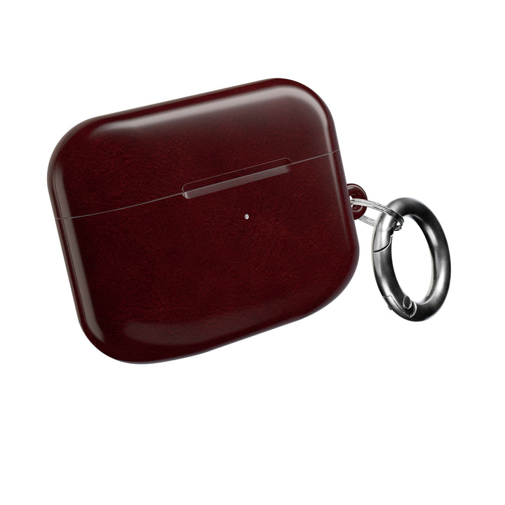 Sunday Theory burgundy glossy polycarbonate AirPod case with a silver carabiner for secure attachment.