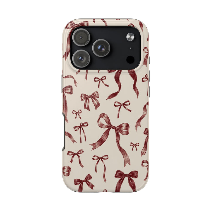 Sunday Theory protective phone case with a cream background and burgundy hand-sketched bow pattern in a glossy finish.