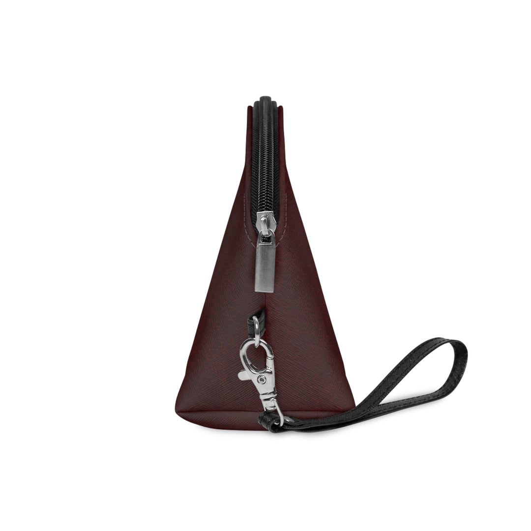 Sunday Theory burgundy leatherette cosmetic pouch with a triangular shape, black zipper, and wrist strap