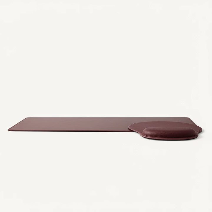 Sunday Theory burgundy leather-look desk mat and ergonomic mouse pad with memory foam wrist rest on white background.