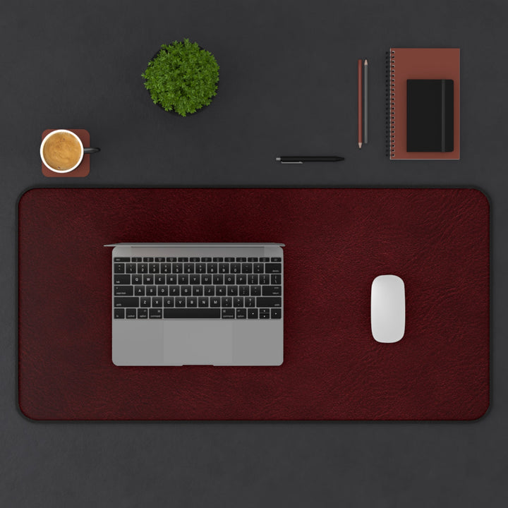 Sunday Theory burgundy leather-look desk mat and ergonomic mouse pad set with laptop and accessories on a dark desk