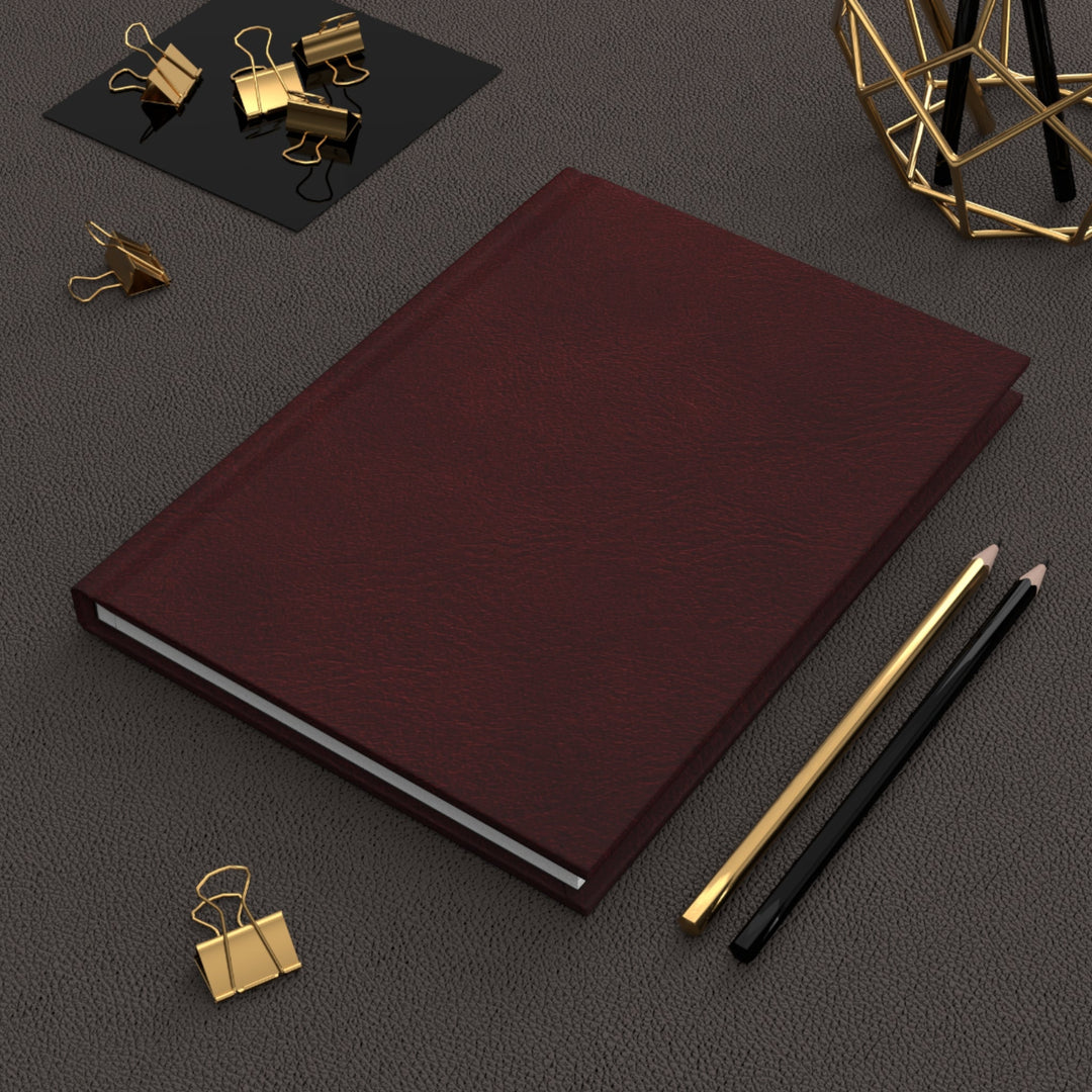 Sunday Theory burgundy matte hardcover journal with lined pages, styled with gold binder clips and pencils.
