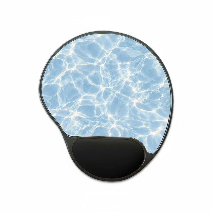 Sunday Theory ergonomic mouse pad with blue water ripple print and black memory foam wrist rest on a foot-shaped base.