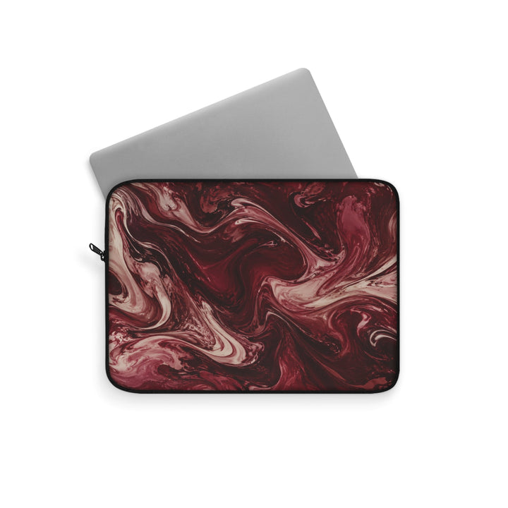 Sunday Theory maroon and cream marble swirl laptop sleeve with a silver laptop partially inserted.