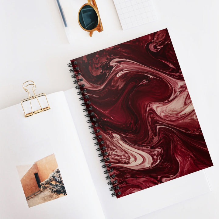 Sunday Theory maroon marble spiral notebook with cream swirls, open to show ruled pages and a gold binder clip.