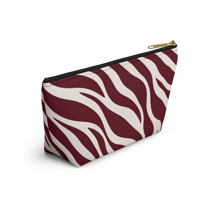 Sunday Theory maroon and cream zebra print polyester accessory pouch with a gold zipper and stable T-bottom design.