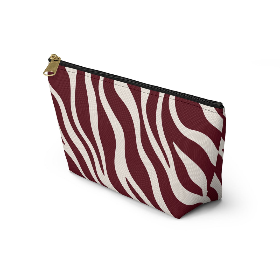 Sunday Theory maroon and cream zebra print polyester accessory pouch with a gold zipper and stable T-bottom design.