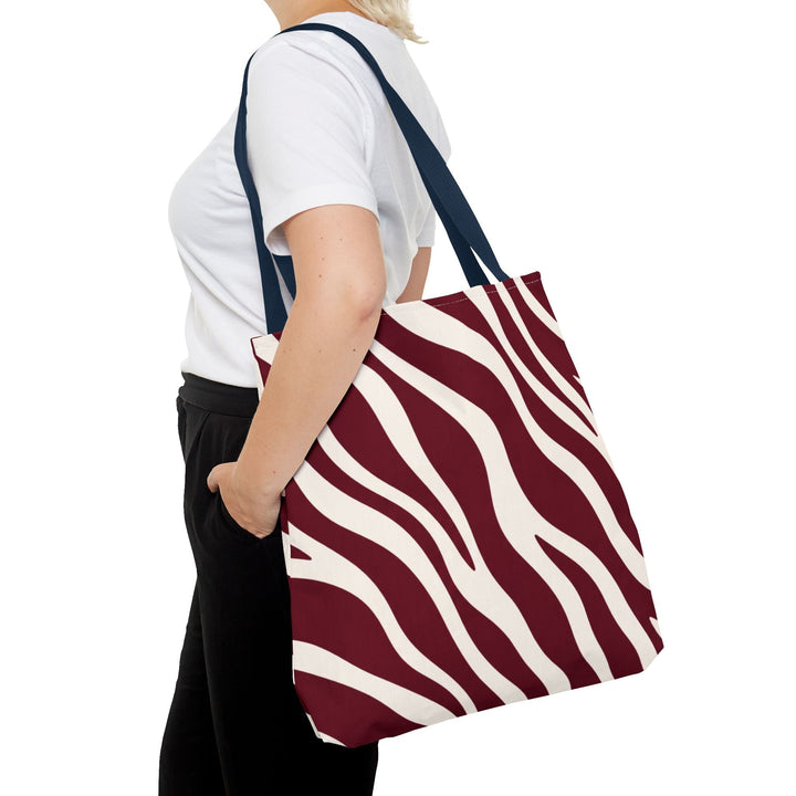 Sunday Theory maroon and cream zebra print tote bag worn over the shoulder by a person in a white t-shirt
