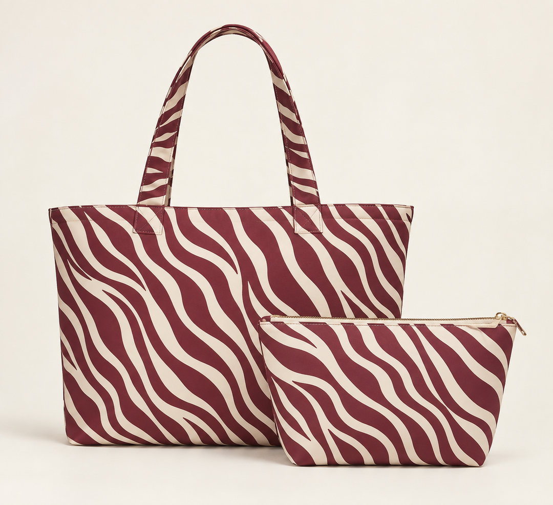 Sunday Theory maroon and cream zebra print tote bag and matching accessory pouch set on a light background
