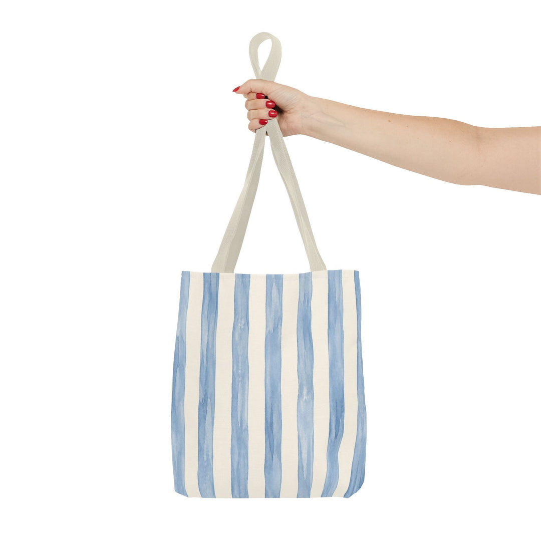 Sunday Theory striped blue watercolor canvas tote bag held by a hand against a clean white background